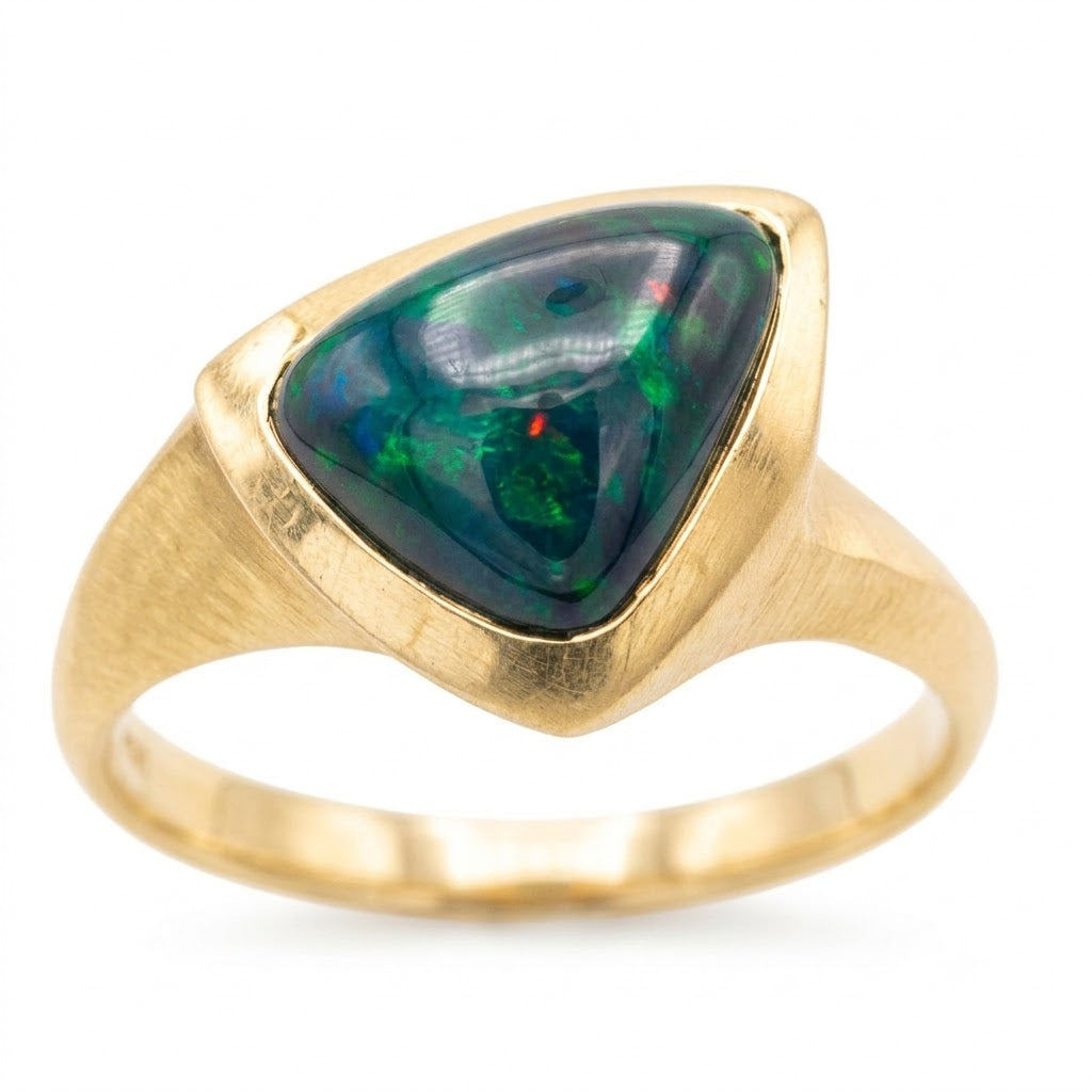 Opal Bezel Ring in Gold — Ethiopian black opal with deep green and blue fire  is harmoniously set in a 18k gold flowing bezel setting, hand-carved and solid cast